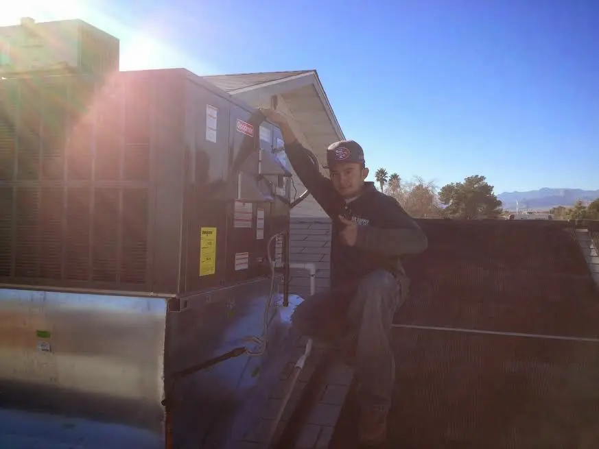 HVAC technician performing Air Duct Cleaning on a rooftop unit in Bridge City
