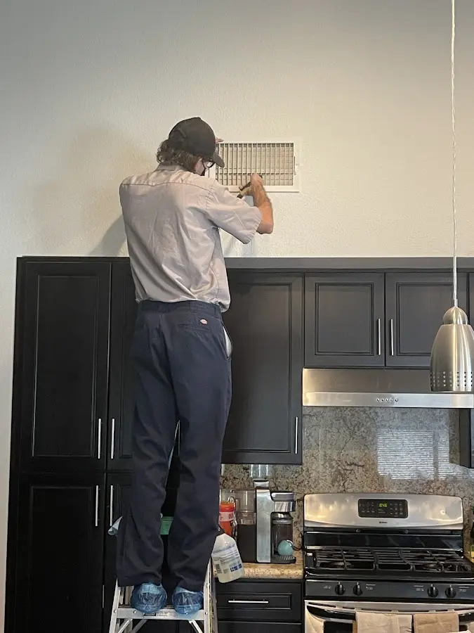 Technician inspecting an air vent during HVAC service in Bridge City